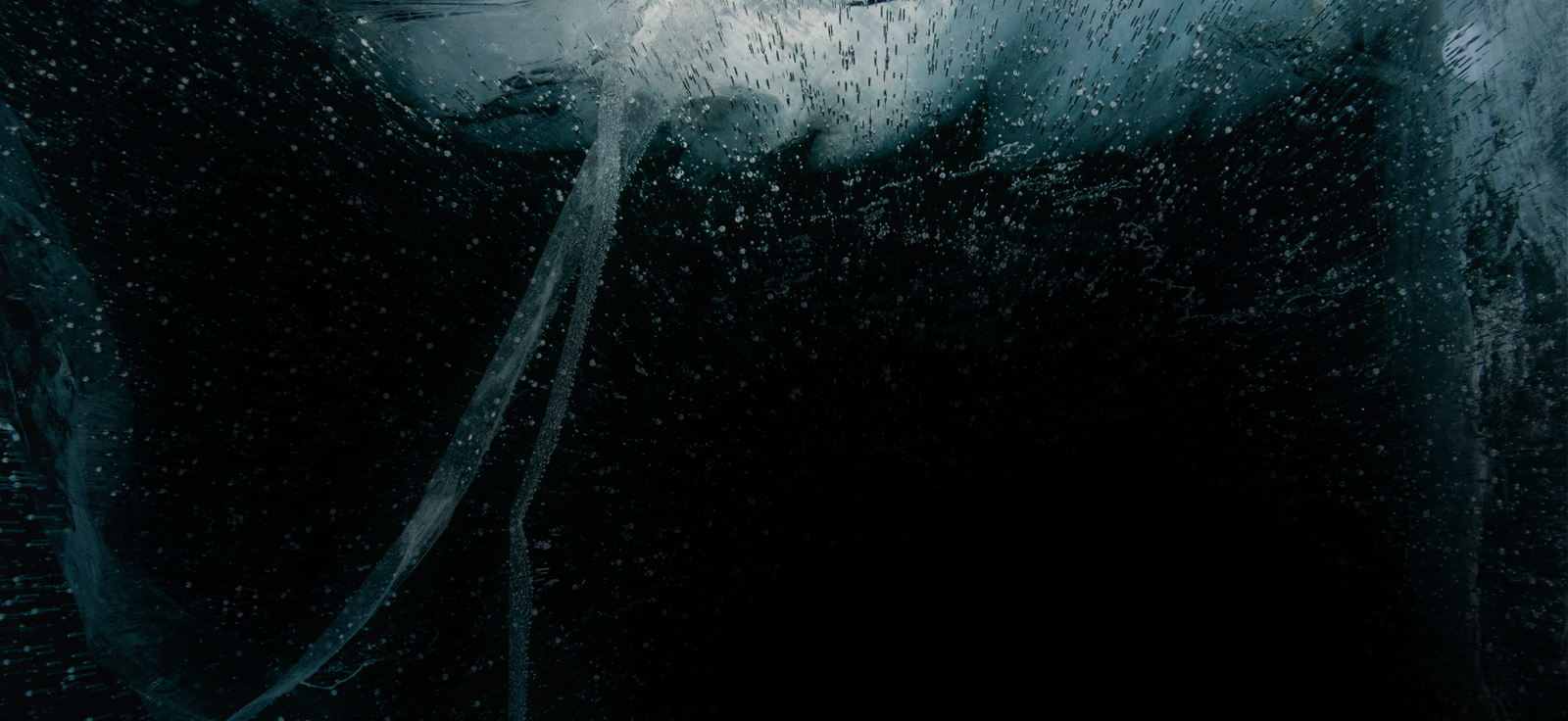 Close-up van ijskristallen en luchtbellen in koud water, donkere cinematic still