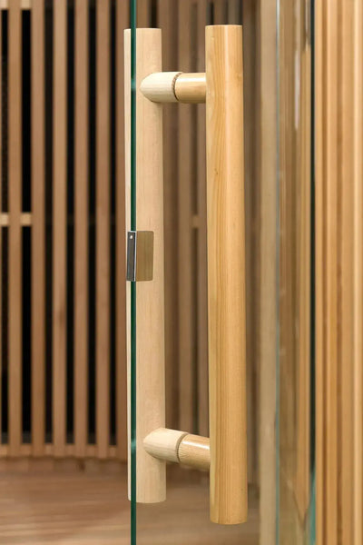 Close-up van de houten deurgreep en glazen deur van de ICEO Maan infraroodsauna in houtkleur